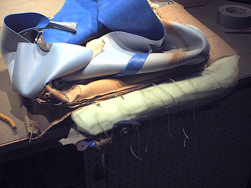 Original seat upholstery placed on seat, ready to be secured back into place